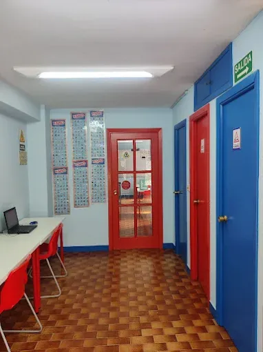 Recepción y pasillo de la sede de Nigrán, con mesa de atención y láminas didácticas en las paredes